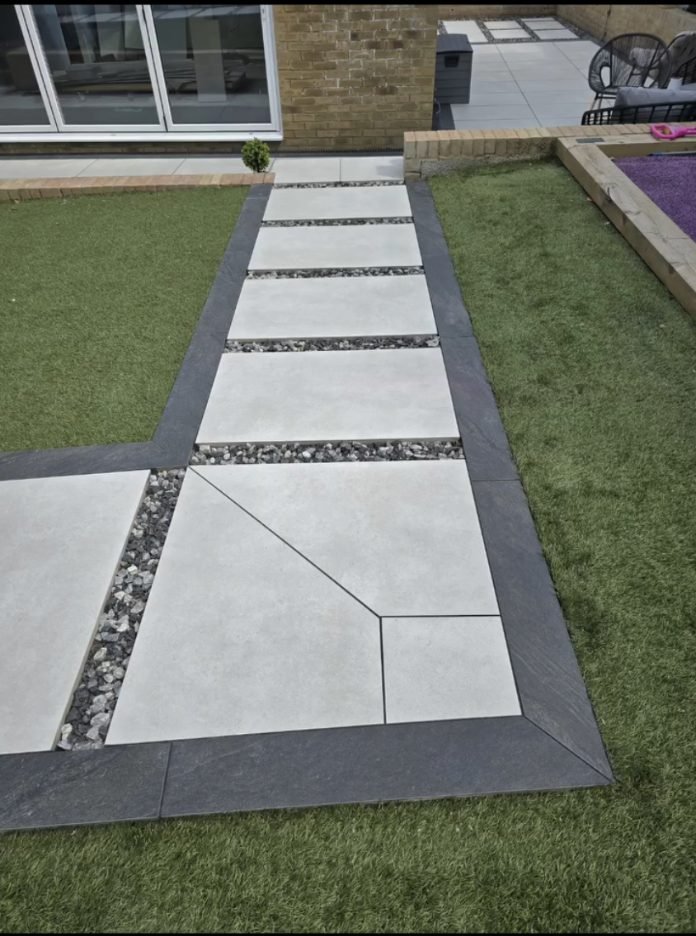 A pale porcelain path framed in dark porcelain, with a slab cut on the diagonal where the path turns.
